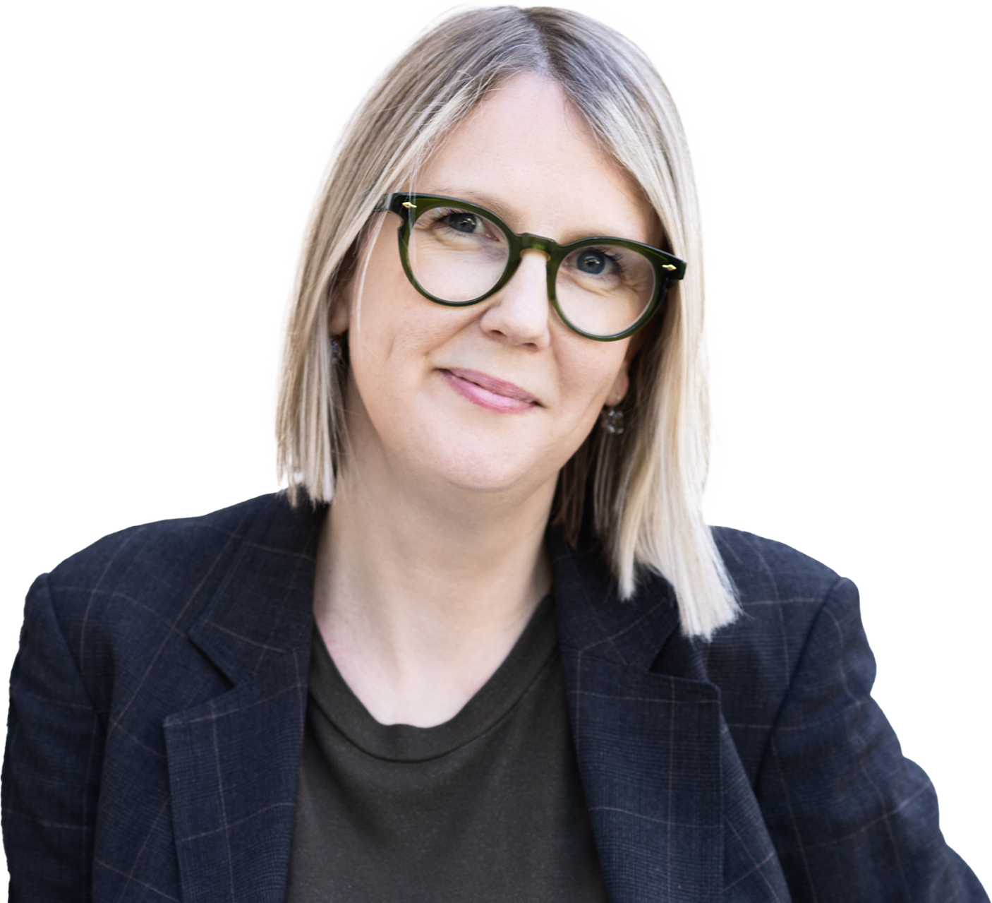 Jenny, a woman with straight blonde hair and green-framed glasses, wearing a dark plaid blazer over a dark top, smiling slightly at the camera.